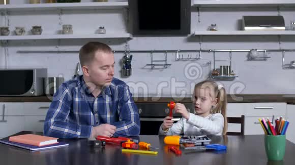父亲向学龄前女孩解释扳手的使用视频的预览图