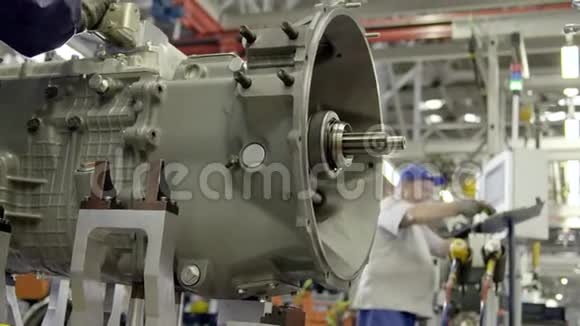 在工厂和工人的背景下对工厂机器的大部分进行了特写场景部分圆形机器视频的预览图