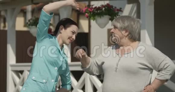 老年妇女接受理疗师在医院康复中心进行锻炼和伸展治疗视频的预览图