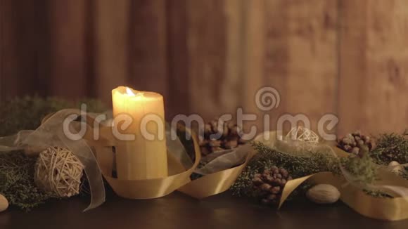 用点燃的蜡烛松枝天然的松果金色的缎子和白色的风琴点燃的火焰把圣诞节的环境关上视频的预览图