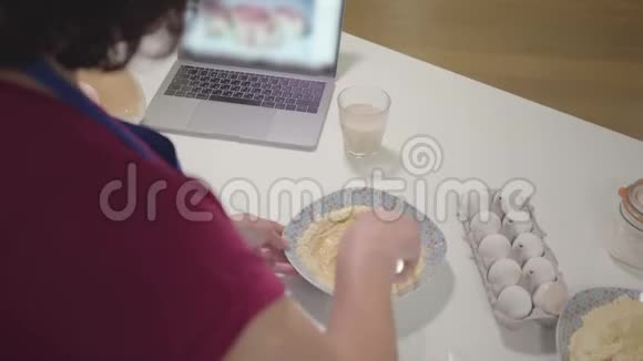 成熟的白种人女人在盘子里混合面团高级女性退休人员在家做饭爱好休闲活动视频的预览图