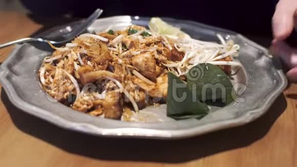 女孩在泰国著名的菜肴上撒糖泰国菜面条鸡肉豆腐罗望子酱豆芽视频的预览图