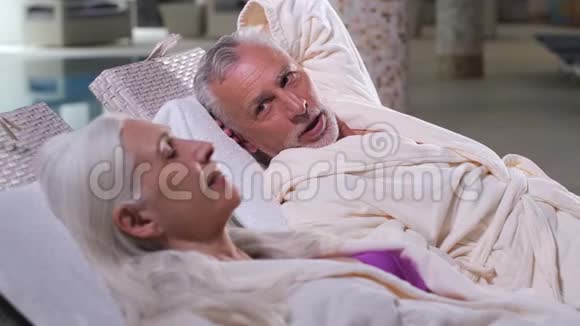 在谈话中老夫妇在日光浴床上放松视频的预览图
