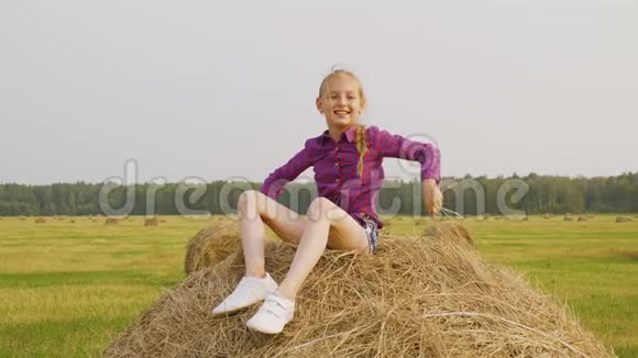 女孩把稻草撒在田野上视频的预览图