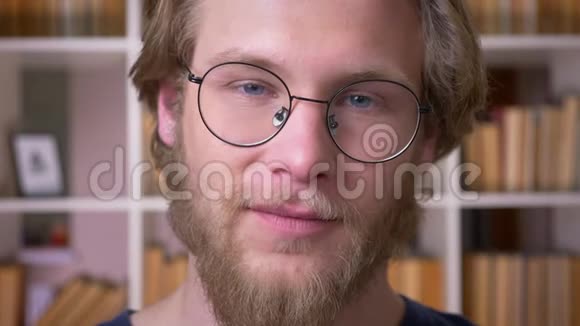 大学里一位戴眼镜微笑着点头看着镜头的成年帅哥的特写镜头视频的预览图