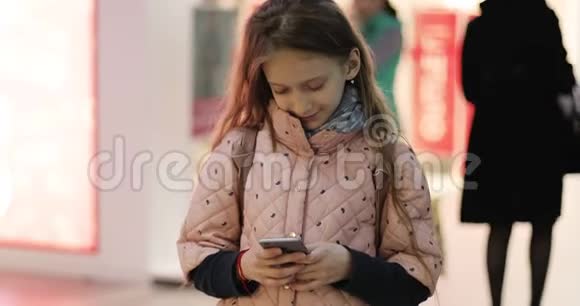 一个可爱的女学生手里拿着一部手机在网上购物视频的预览图