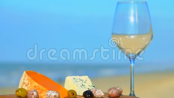 红酒倒在奶酪板旁边的玻璃杯里视频的预览图