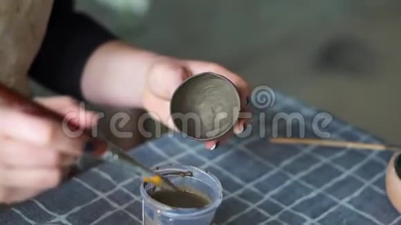 女的手绘棕色粘土杯陶工工作室视频的预览图