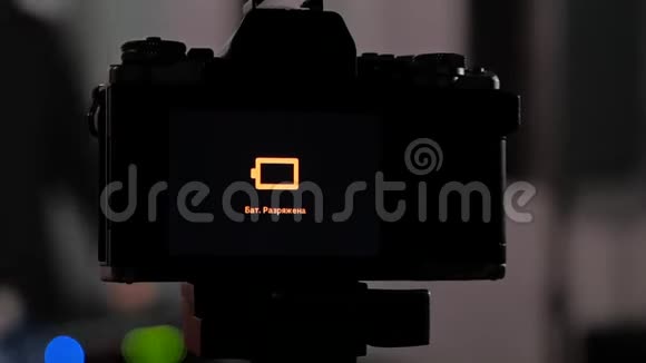 照片工作室的三脚架上的相机显示它已经耗尽了电池的能量相机关了视频的预览图