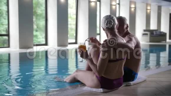 一对老年夫妇在游泳池旁放松视频的预览图