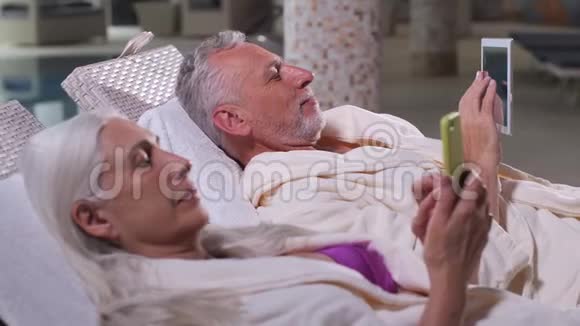 在温泉酒店度假的老夫妇使用电话视频的预览图