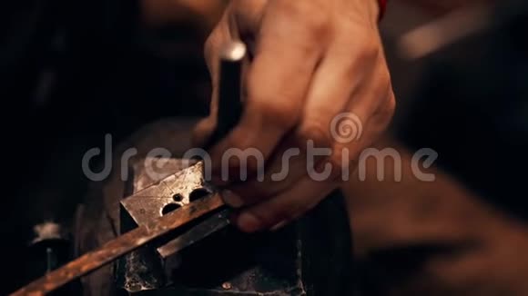 一个铁匠正在铁砧上锤一把小刀快关门房间视频的预览图