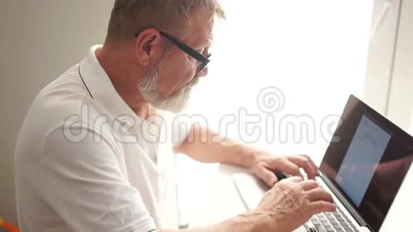 工作中的作家或科学家一位老人用电脑写一封信远程就业成熟的男人用视频的预览图