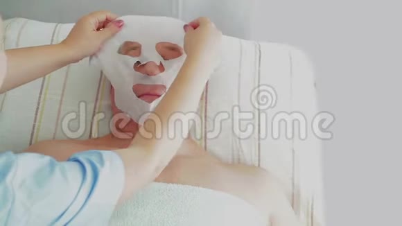 女性美容师让客户成为一个男人在水疗沙龙保湿面膜视频的预览图
