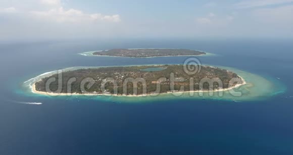 迷人的海滩和深蓝色的海洋从上面巴厘岛孤岛有船的码头白色沙滩和棕榈树视频的预览图