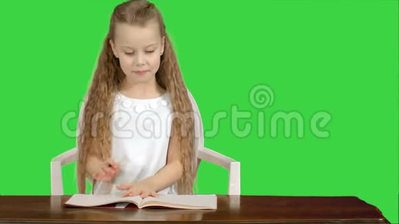 小女孩在绿色屏幕上写书Chroma键视频的预览图