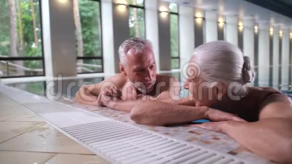 快乐的成熟情侣在室内泳池边放松视频的预览图