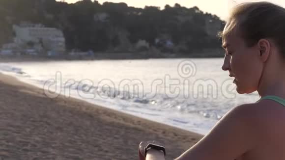 在海滩上使用健身手镯训练的女人视频的预览图