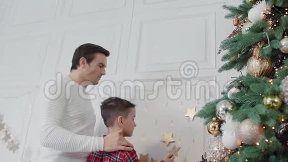 微笑的父亲和儿子一起装饰客厅视频的预览图