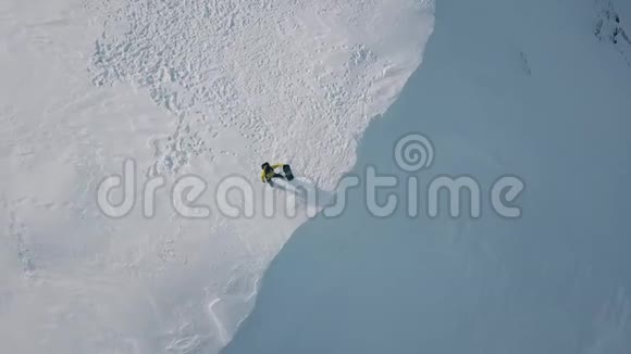 空中旋转射击男子与滑雪板站在白色晴雪包围视频的预览图