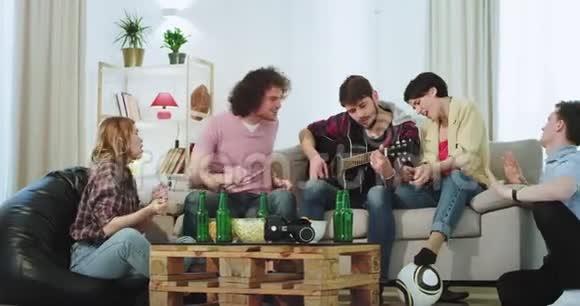 在一个现代化的房子里一群漂亮的人在一个宽敞的客厅里一起用吉他唱歌和跳舞玩得很开心视频的预览图