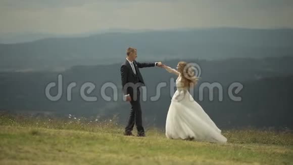 新郎新娘在山上玩得开心结婚新娘在跳舞视频的预览图