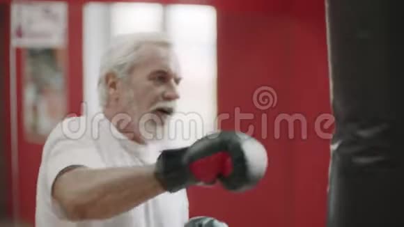健康俱乐部有氧训练的高级拳击手视频的预览图