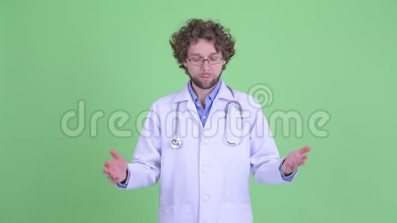 一个满脸胡须的年轻医生一边耸肩一边看着悲伤视频的预览图
