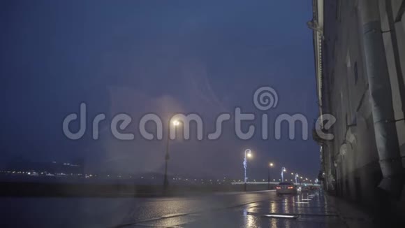 秋季雨城街道夜间夜间雨期湿路交通路灯映水洼运动视频的预览图