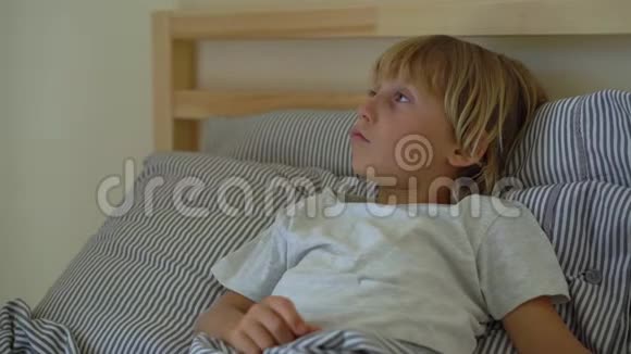 在床上生病的小男孩妈妈吻了吻他用精油男孩的胸部涂上药膏婴儿流感概念视频的预览图