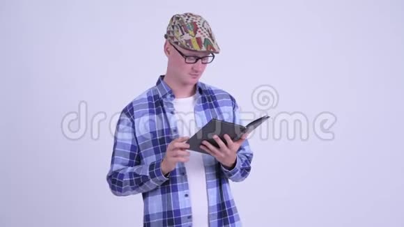 快乐的年轻时髦男人看起来害羞用书遮住脸视频的预览图