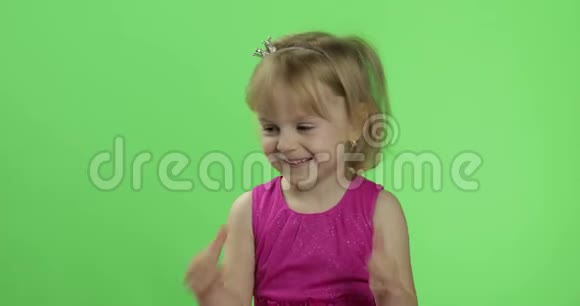 穿粉色连衣裙的女孩竖起大拇指快乐的四岁女孩色度键视频的预览图