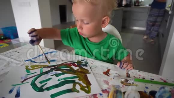 特写小男孩用画笔作画小创作艺术家专注于他的作品视频的预览图