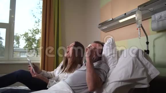 生病的夫妻在诊所看喜剧视频的预览图