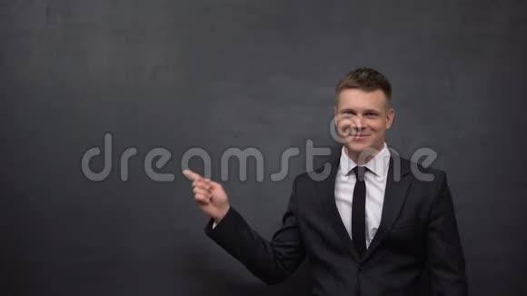 一个穿着西装的微笑男人用手指指着黑板商业车间成功视频的预览图