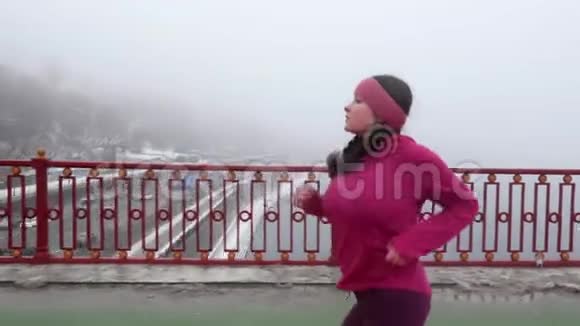 年轻胖乎乎的白种人女孩在桥上奔跑侧射慢动作紫色服装视频的预览图