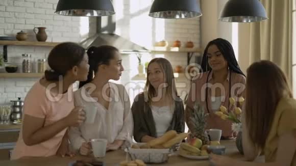 厨房里有5个女朋友喝茶谈论生活伤心的女孩互相支持视频的预览图