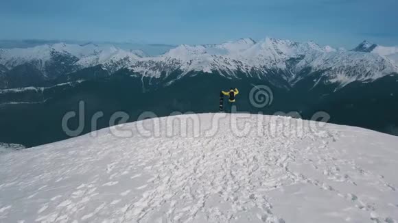 空中射击男运动员举着滑雪板冠军站在高山仰视顶上视频的预览图