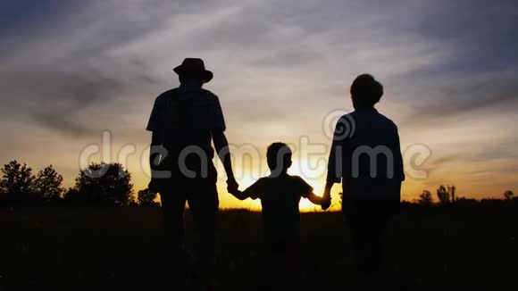 祖父母和小孙子在日落时散步视频的预览图