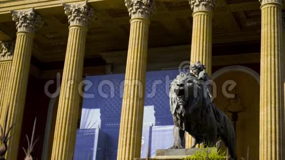 狮子雕像与妇女的背景柱行动女人的雕像坐在咆哮的狮子入口视频的预览图