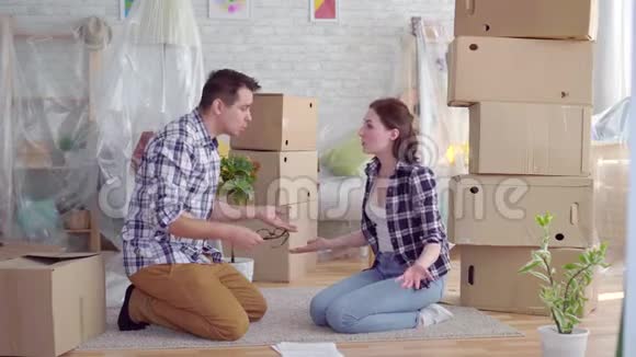 疲惫而沮丧的一对中年男女在移动的箱子中间争吵视频的预览图