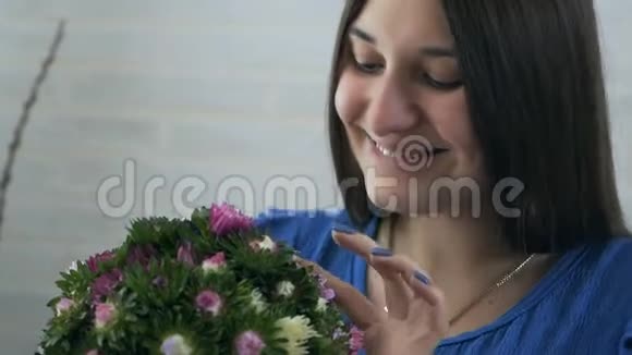 一位年轻的孕妇嗅着一朵花过敏视频的预览图