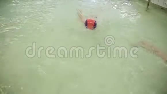 一个女孩在水下游泳一个穿泳衣的女孩在游泳池里学水下游泳视频的预览图