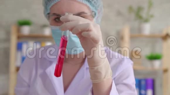 关闭一名女性实验室助理在试管中进行流体研究视频的预览图