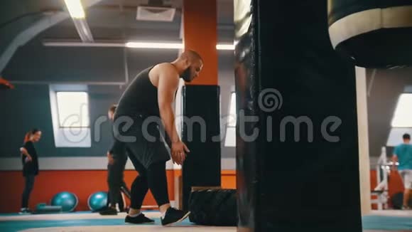 一个长胡子的健美男子在健身房里一遍又一遍地翻着地板上的轮胎视频的预览图