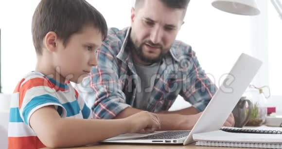 父亲指导儿子使用笔记本电脑视频的预览图