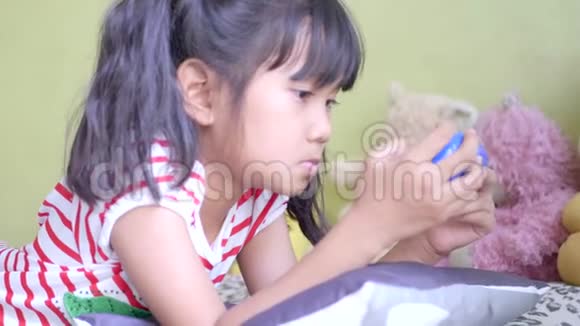 亚洲小女孩在客厅玩电子游戏视频的预览图
