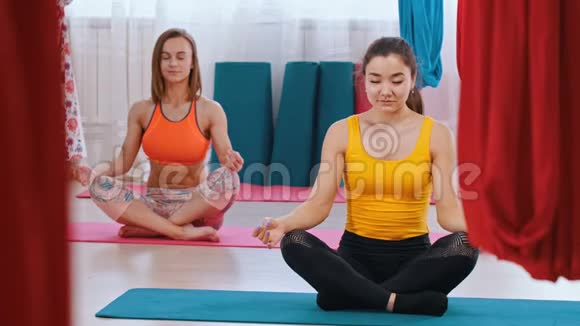 瑜伽两个女人坐在垫子上做呼吸练习视频的预览图