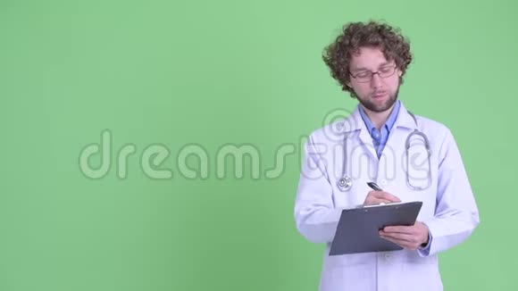 快乐的小胡子男医生在剪贴板上写东西视频的预览图