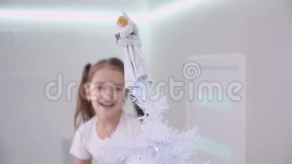 可爱的小女孩渴望在圣诞树的顶端找到一个天使装饰视频的预览图